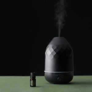 A stylish essential oil diffuser emits vapor, creating a serene atmosphere with a focus on well-being.