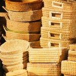 A collection of handwoven baskets displayed in warm sunlight, showcasing artisanship and texture.