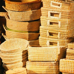 A collection of handwoven baskets displayed in warm sunlight, showcasing artisanship and texture.